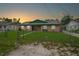 Charming single-story home featuring a well-maintained lawn, a chainlink fence, and a colorful sky at 312 E Tomlin St, Plant City, FL 33563