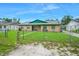 Charming single-story home featuring a well-maintained lawn, a chainlink fence, and a beautiful blue sky at 312 E Tomlin St, Plant City, FL 33563