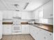 Bright kitchen featuring all-white appliances and cabinets, with modern countertops at 312 E Tomlin St, Plant City, FL 33563
