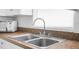 Close-up of a stainless-steel kitchen sink with a modern faucet and a bright window at 312 E Tomlin St, Plant City, FL 33563