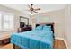 Bedroom featuring a ceiling fan, dark wood furniture, and a bed with a blue quilt at 3129 W Villa Rosa St, Tampa, FL 33611