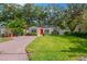 Inviting single-story home with well-manicured lawn, brick driveway, solar panels, and cheerful yellow siding at 3129 W Villa Rosa St, Tampa, FL 33611