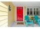 Close-up of the entrance with a vibrant red door and cozy seating area, enhanced by nautical decor at 3129 W Villa Rosa St, Tampa, FL 33611