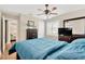 Bedroom with a ceiling fan, window with blinds, and a comfortable blue quilt on the bed at 3129 W Villa Rosa St, Tampa, FL 33611
