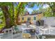 Backyard patio with fire pit and comfortable seating beneath a large shade tree at 3129 W Villa Rosa St, Tampa, FL 33611