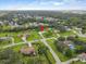 An aerial shot of a residential neighborhood surrounded by mature trees under a blue sky with scattered clouds at 3515 E 34Th St, Bradenton, FL 34208