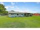 Backyard with a green lawn and a home with green siding at 3515 E 34Th St, Bradenton, FL 34208