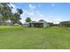 Large grassy backyard with green home in the background at 3515 E 34Th St, Bradenton, FL 34208