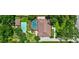Aerial view featuring a large in-ground screened pool, a green tennis court, home and large lawn at 3923 Hudson Ln, Tampa, FL 33618