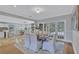 Bright dining room with wood table, white chairs, area rug, and french doors leading to outdoor pool area at 3923 Hudson Ln, Tampa, FL 33618