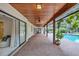 Covered patio with brick floors, ceiling fans, and access to the pool area at 3923 Hudson Ln, Tampa, FL 33618