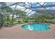 Enclosed pool area with lounge chairs, lush landscaping, and screened enclosure at 3923 Hudson Ln, Tampa, FL 33618