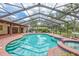 Enclosed pool area and manicured landscaping viewed from the poolside brick patio at 3923 Hudson Ln, Tampa, FL 33618