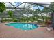 Enclosed pool with screened enclosure, brick patio and exterior landscaping at 3923 Hudson Ln, Tampa, FL 33618