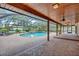 Enclosed pool area featuring a brick patio, ceiling fans, and tropical landscaping at 3923 Hudson Ln, Tampa, FL 33618