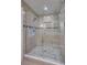 Modern walk-in shower features tiled walls, mosaic floor, seating, and glass enclosure at 3923 Hudson Ln, Tampa, FL 33618