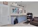 Charming bar area with blue cabinetry, a convenient sink, and stylish shelving for storage and display at 4147 Grandchamp Cir, Palm Harbor, FL 34685