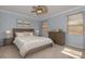 Bedroom with wood trim, a ceiling fan, neutral-toned bedding, and matching dressers at 4147 Grandchamp Cir, Palm Harbor, FL 34685
