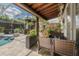 Relaxing covered patio with wicker seating and plants, connecting to the outdoor living space and pool at 4147 Grandchamp Cir, Palm Harbor, FL 34685