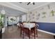 Bright dining area featuring wood floors, table with seating, and decorated display shelves and view into the living room at 4147 Grandchamp Cir, Palm Harbor, FL 34685