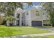 Two-story home featuring an arched entryway, well-kept lawn, and a two-car garage at 4147 Grandchamp Cir, Palm Harbor, FL 34685