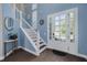 Bright foyer with a staircase, hardwood floors, and a decorative sun mirror at 4147 Grandchamp Cir, Palm Harbor, FL 34685
