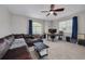 Bright living room featuring a large brown sectional, ceiling fan, and an area for remote work at 4147 Grandchamp Cir, Palm Harbor, FL 34685