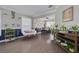 Comfortable living room with hardwood floors, decorated display shelves, and dining area view, enhanced by ample natural light at 4147 Grandchamp Cir, Palm Harbor, FL 34685