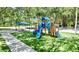 Community playground with blue slides and green synthetic grass at 4147 Grandchamp Cir, Palm Harbor, FL 34685