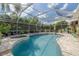Relaxing screened-in pool area featuring a jacuzzi and plenty of seating on the patio at 4147 Grandchamp Cir, Palm Harbor, FL 34685