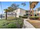 Condominium exterior featuring stucco walls, a sign, palm trees, green shrubs, and a walkway on a sunny day at 4611 W North B St # 228, Tampa, FL 33609