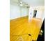 Bright living room with golden wood floors, mirrored wall, ceiling fan, and an open doorway at 4611 W North B St # 228, Tampa, FL 33609