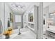 A well-lit bathroom featuring a large mirror, white cabinets and vanity, and a view into the next room at 4743 Spinnaker Dr, Bradenton, FL 34208