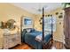 Comfortable bedroom features a dark wood canopy bed, floral decorations and a large window at 4743 Spinnaker Dr, Bradenton, FL 34208