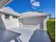 Attached two car garage showcasing driveway, updated door and lush, green landscaping at 4743 Spinnaker Dr, Bradenton, FL 34208