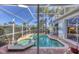 Screened pool and spa area featuring brick patio and lush landscaping for privacy at 4743 Spinnaker Dr, Bradenton, FL 34208