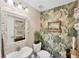 Unique powder room with tropical wallpaper, a decorative mirror, and a stylish vanity at 4743 Spinnaker Dr, Bradenton, FL 34208