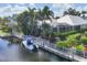 Beautiful waterfront home featuring lush landscaping, boat dock, and stunning architectural design at 4743 Spinnaker Dr, Bradenton, FL 34208