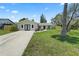 Inviting single-story home with fresh exterior paint, a well-manicured lawn, and a concrete driveway at 561 Golf And Sea Blvd, Apollo Beach, FL 33572