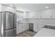 Well-lit kitchen showcasing new white cabinets, quartz countertops, and a stainless-steel refrigerator at 561 Golf And Sea Blvd, Apollo Beach, FL 33572