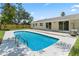 Backyard pool, light stone patio, newly constructed fence and exterior of the home, with updated paint and windows at 561 Golf And Sea Blvd, Apollo Beach, FL 33572