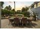 Backyard patio with a dining table, chairs, and a view of the lush landscaping and pool at 58 Aster St, Clearwater Beach, FL 33767