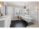 Bright bathroom features a clawfoot tub, walk-in shower, and sleek vanity with black tile floors at 58 Aster St, Clearwater Beach, FL 33767