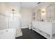 Elegant bathroom boasts a luxurious shower, vanity with dual mirrors, and sleek black tile flooring at 58 Aster St, Clearwater Beach, FL 33767