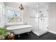 Elegant bathroom featuring a soaking tub, walk-in shower, and stylish black and white tile at 58 Aster St, Clearwater Beach, FL 33767