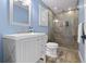 Renovated bathroom with white vanity, sleek fixtures, and a glass-enclosed shower with decorative stone flooring at 58 Aster St, Clearwater Beach, FL 33767