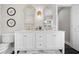 Stylish bathroom featuring dual vanities, decorative mirrors, and a modern toilet at 58 Aster St, Clearwater Beach, FL 33767