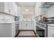 Bright kitchen featuring modern white cabinets, stainless steel appliances, and stylish backsplash at 58 Aster St, Clearwater Beach, FL 33767
