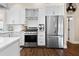 Kitchen featuring stainless steel appliances, white cabinets, and stylish range hood at 58 Aster St, Clearwater Beach, FL 33767