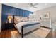 Beautiful main bedroom with a blue accent wall, hardwood floors, and a comfortable bed at 58 Aster St, Clearwater Beach, FL 33767